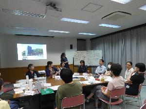 ホワイトボードの前に集まって、数人が話し合いをしている