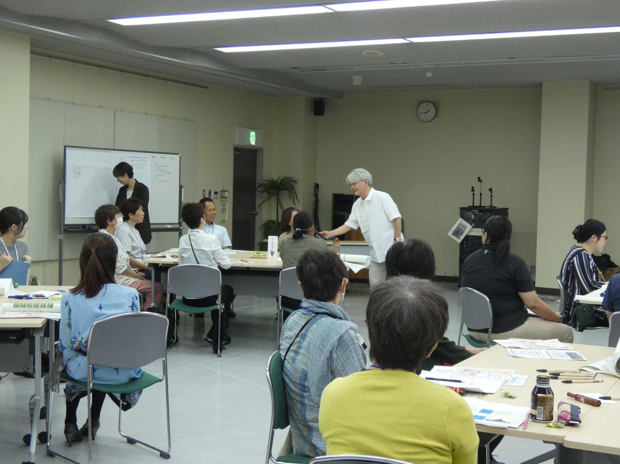吉成氏が講演中に参加者の意見を聞く様子