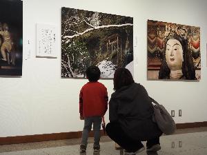 小さな男の子がお母さんとお寺の建物の写真を見ています
