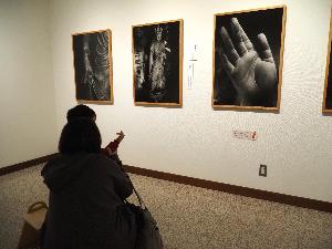 小さな男の子が仏様の手の平の写真を見て、自分の手でその形を真似しています