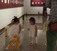 二人の女の子が踏み台の持ち手にバッグをかけようとしています