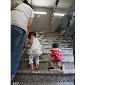 二人のこどもがはいはいで階段をのぼっています。