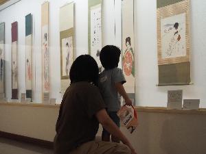 親子で壁に掛けられた夢二の作品を鑑賞しています。
