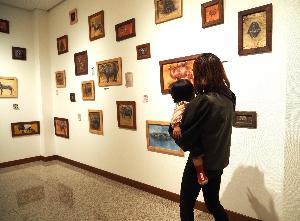 赤ちゃんがママの抱っこで絵を見ています