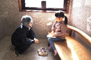 女の子がスタッフとベンチに腰掛けてお話しています。