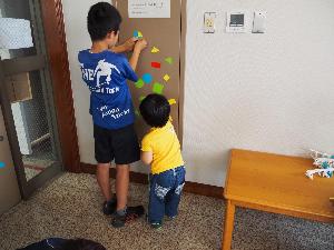 ふたりの子どもがマグネットパズルで遊んでいます。