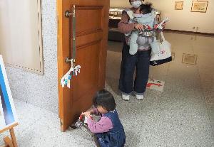 小さな女の子が、展示室の入口に用意されたカードを集めて、専用のバッグに入れています。