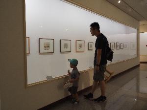 男の子がパパと一緒に絵を見ています