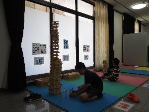 子どもが積み木を高く積み上げて遊んでいます